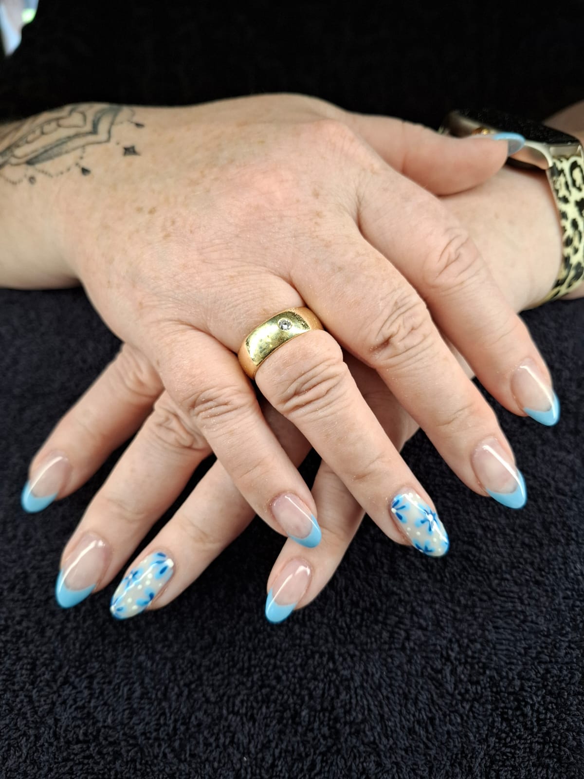 Blau-weißes Nageldesign mit floralen Details