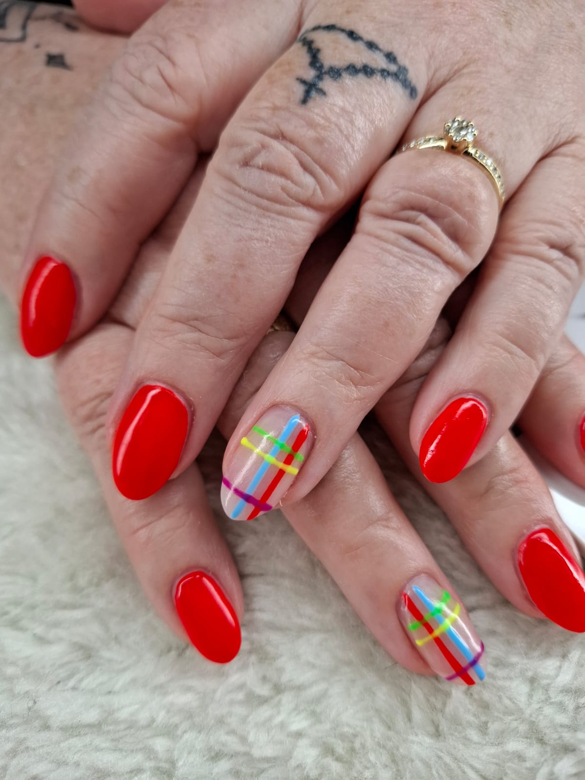 Rote Nägel mit bunten Linien als individuelles Nageldesign